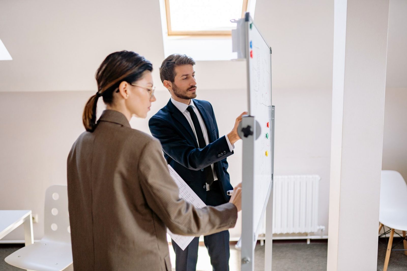 Deux personnes travaillent une stratégie au tableau blanc